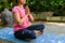 a women practicing  yoga on cotton blue yoga mat  